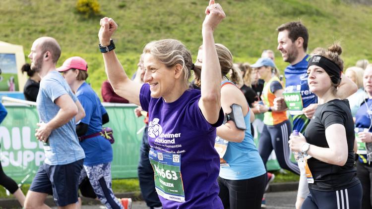A woman celebrates while running for Alzheimer Scotland