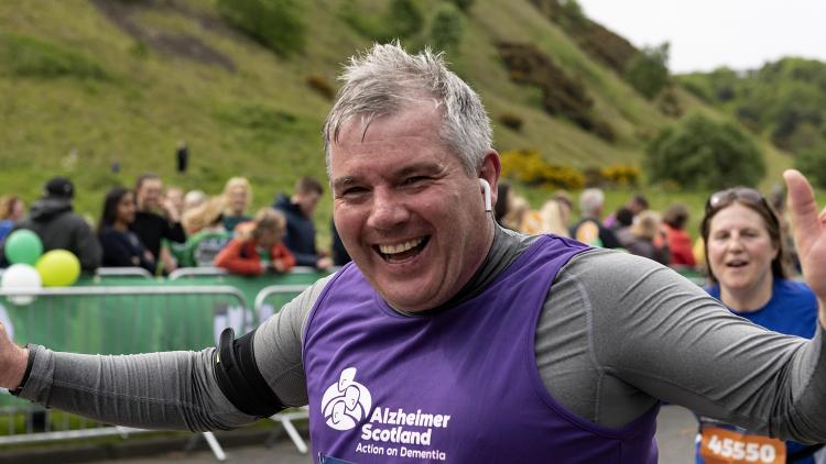 A man cheers running at the Edinburgh Marathon Festival 