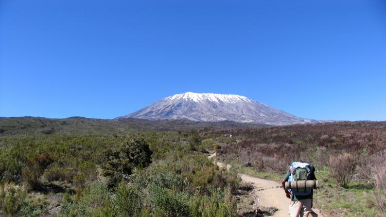 A trekker heads towards Mount Kilimanjaro