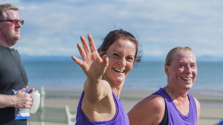 two women wave while running for Alzheimer Scotland
