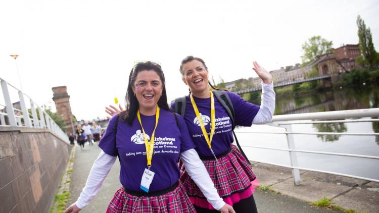 Two women celebrate in pink kilts taking part in the Kiltwalk