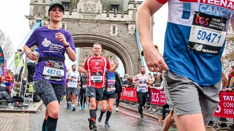 Image of a runner with an Alzheimer Scotland running top on with a background of London Bridge