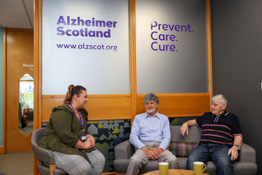 Alzheimer Scotland member of staff talks to attendees at Brain Health and Dementia Resource Centre