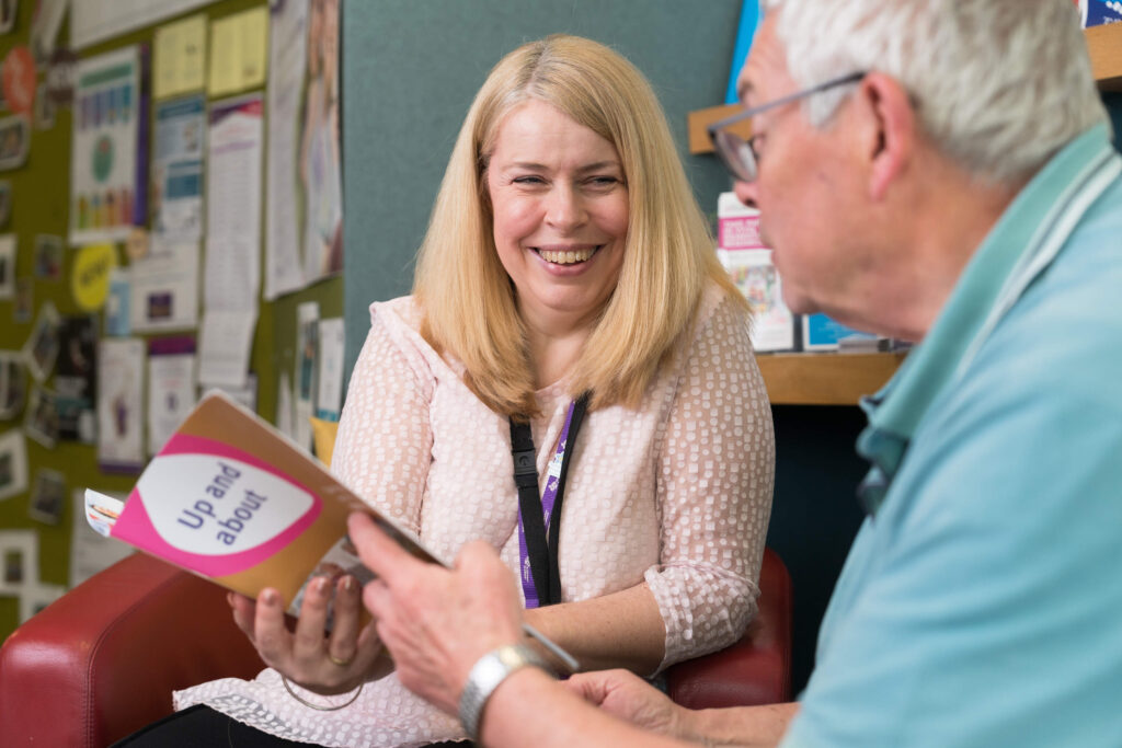 An Alzheimer Scotland member of staff talks to an attendee at a support group