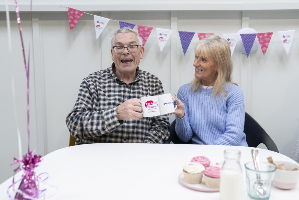 Man and women enjoying Alzheimer Scotland Tea and Blether event