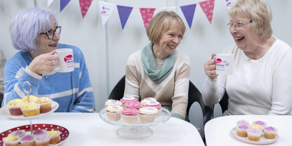 Three women enjoying Alzheimer Scotland Tea and Blether event