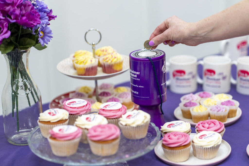 One pound being placed into Alzheimer Scotland donation tin