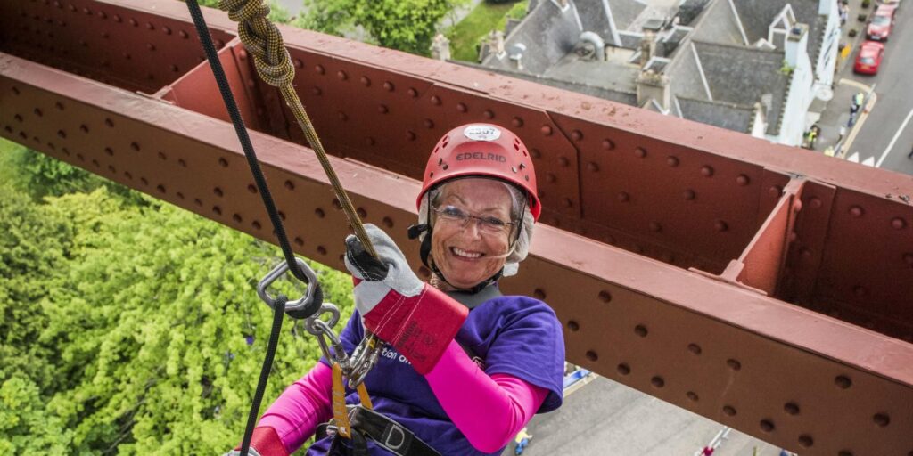Woman abseiling from Forth Rail Bridge for Alzheimer Scotland charity