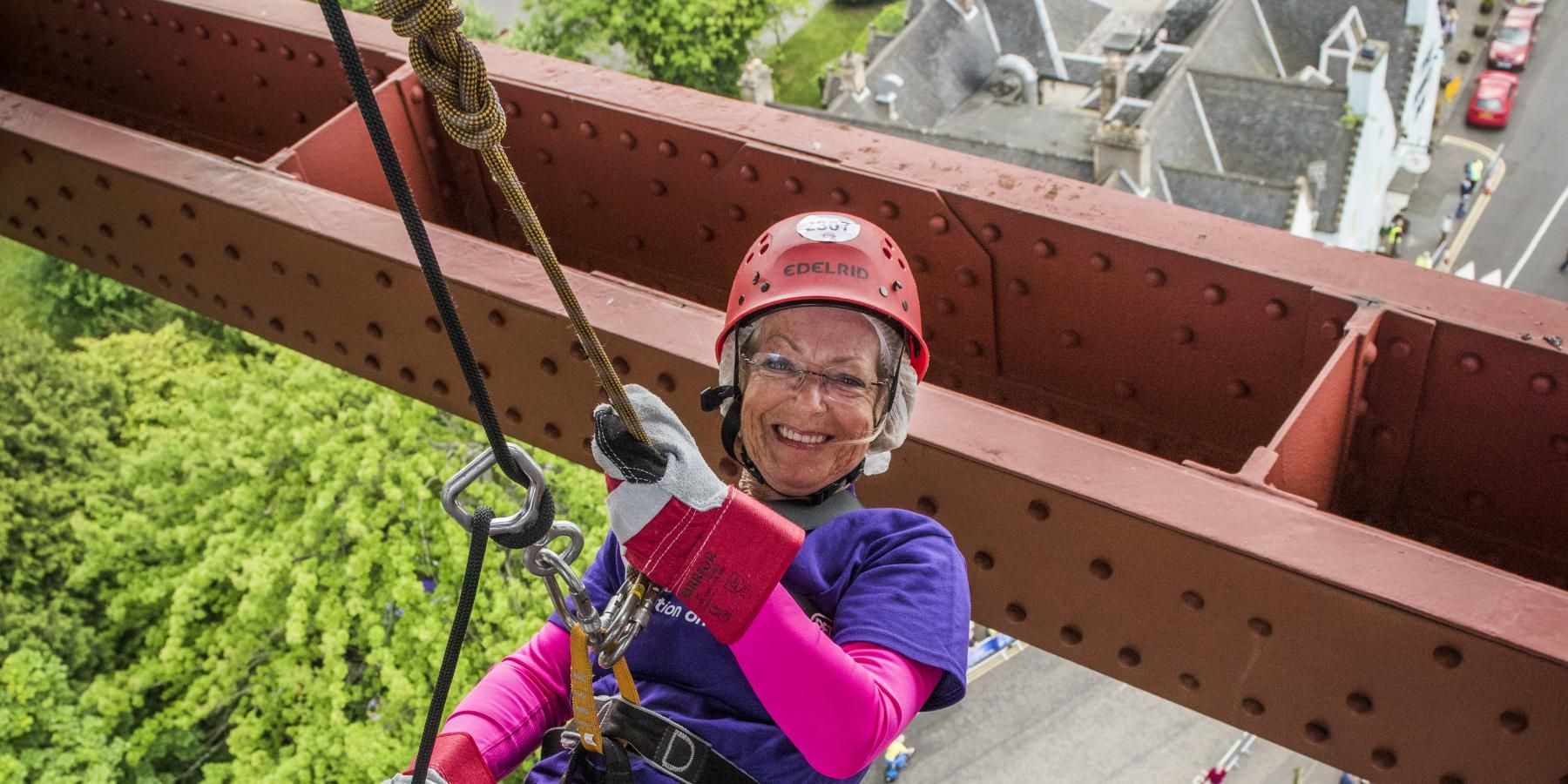 Woman abseiling from Forth Rail Bridge for Alzheimer Scotland charity